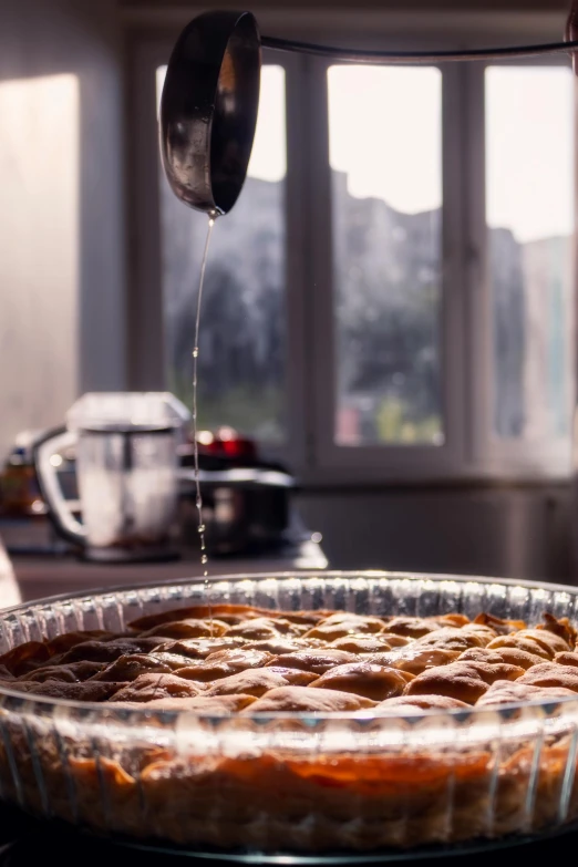 a person pours syrup from a pot into a pie