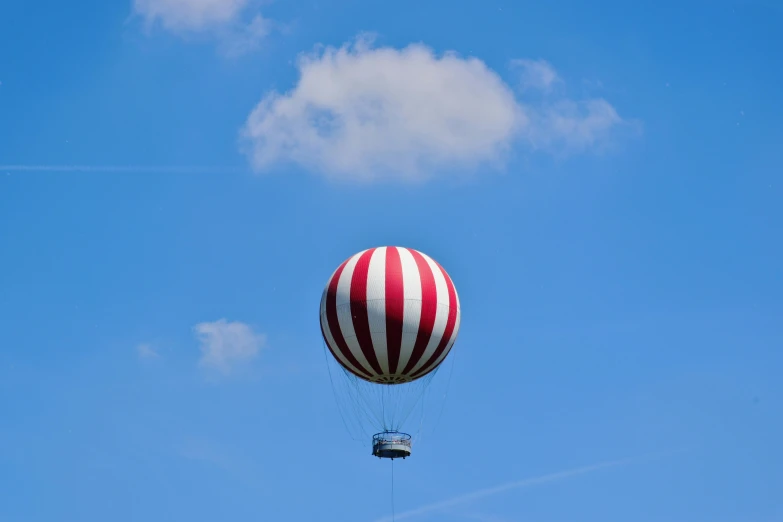 a large white and red striped balloon with a bucket attached