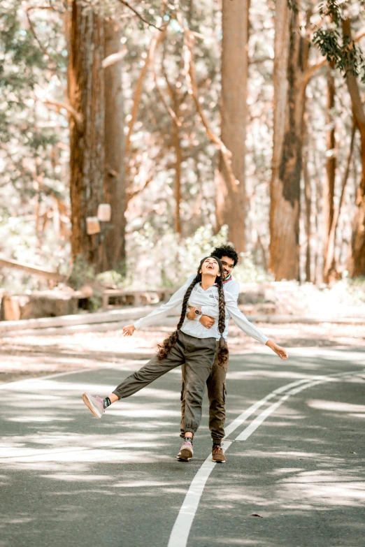 a man and a woman crossing the street in a park