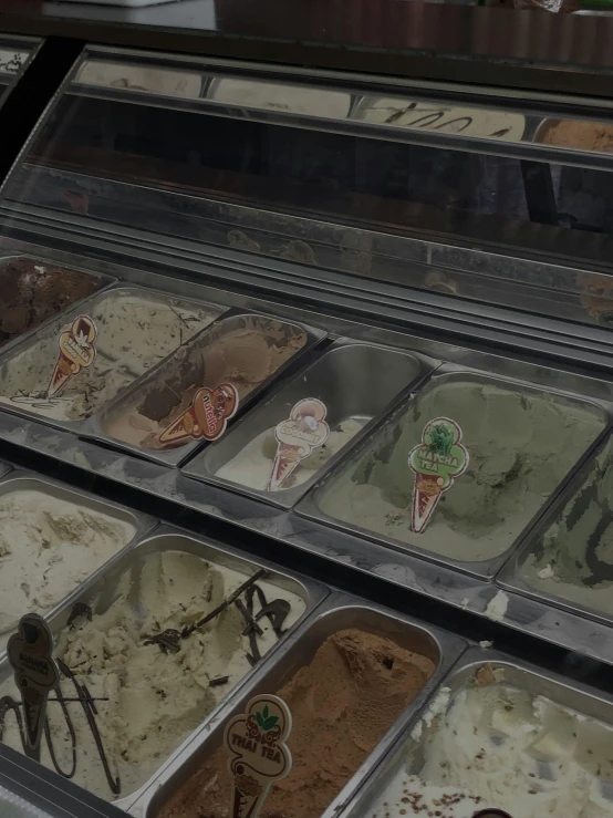 an assortment of gelato and desserts are in a display case