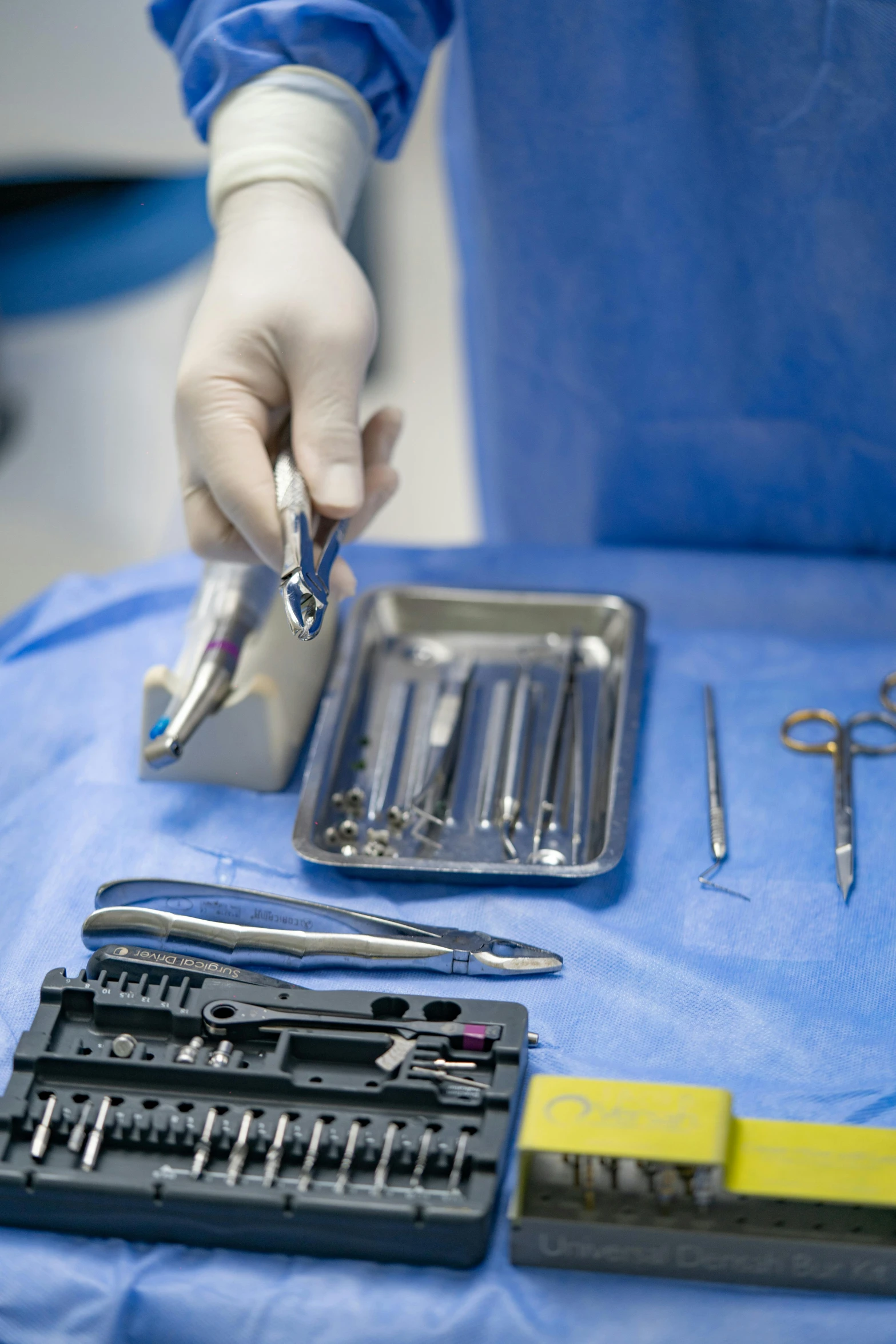 an employee in blue shirt holding tools on a table