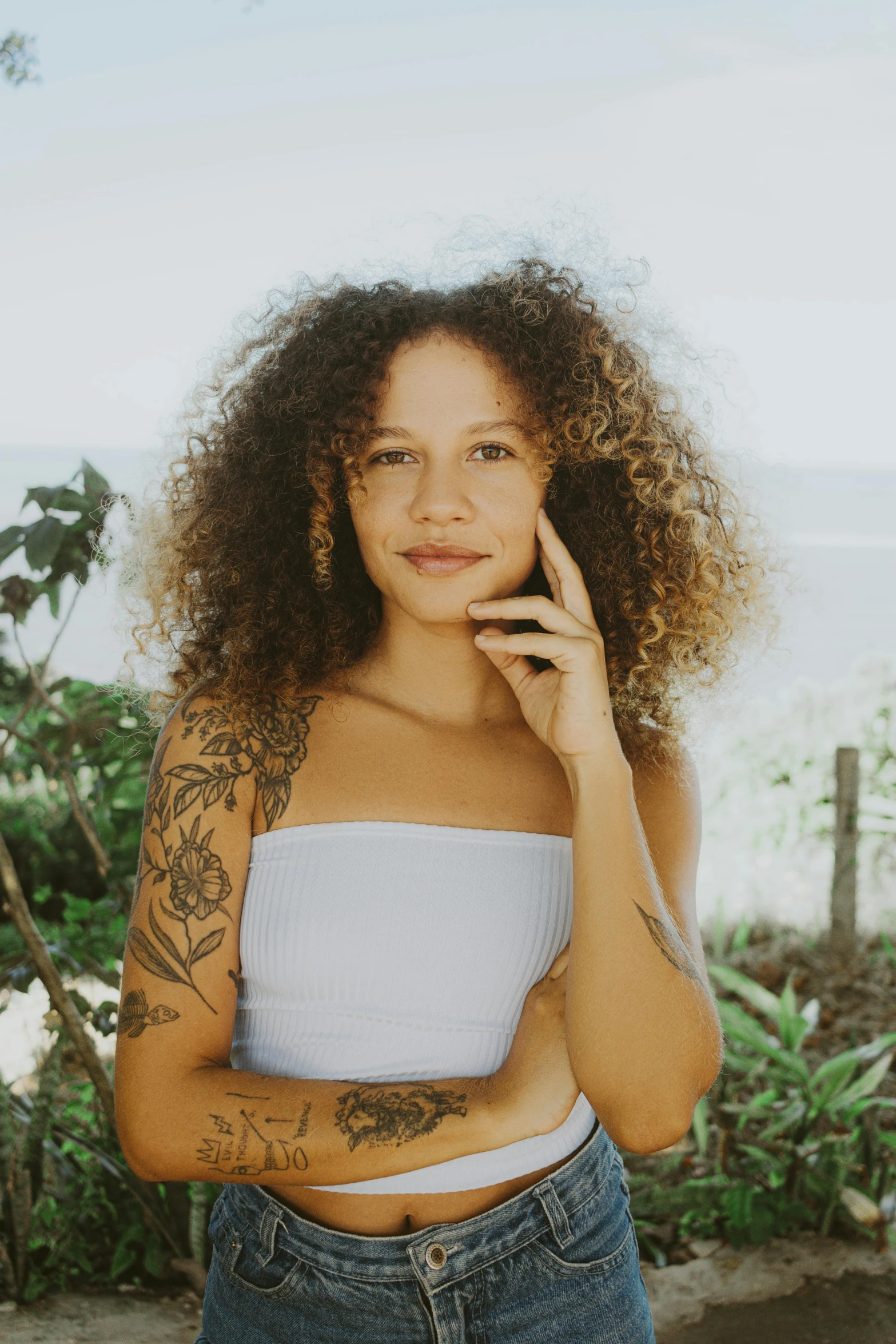 a woman is posing for the camera near trees