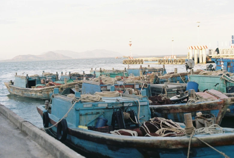 a group of boats parked on the beach near a pier