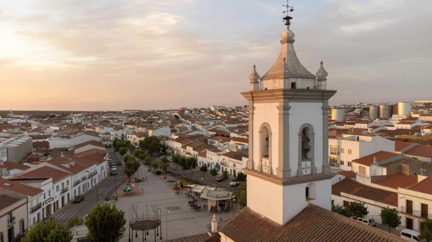 a small church tower next to a group of houses