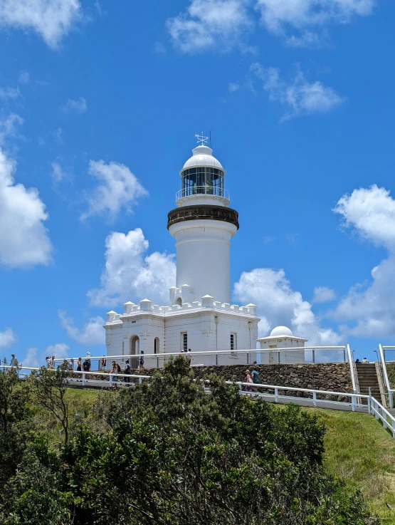 people gather on the side of a lighthouse