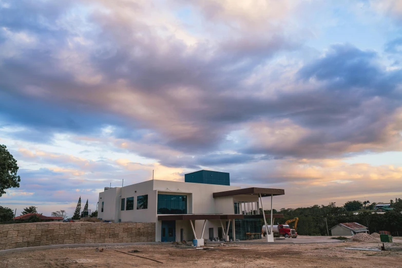 a modern building under a cloudy sky with three men standing in front of it