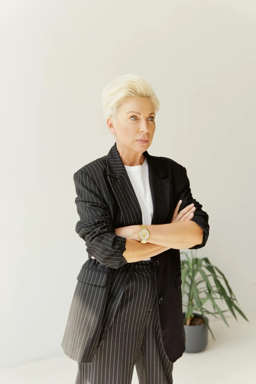 an older woman in a suit and tie posing for a picture