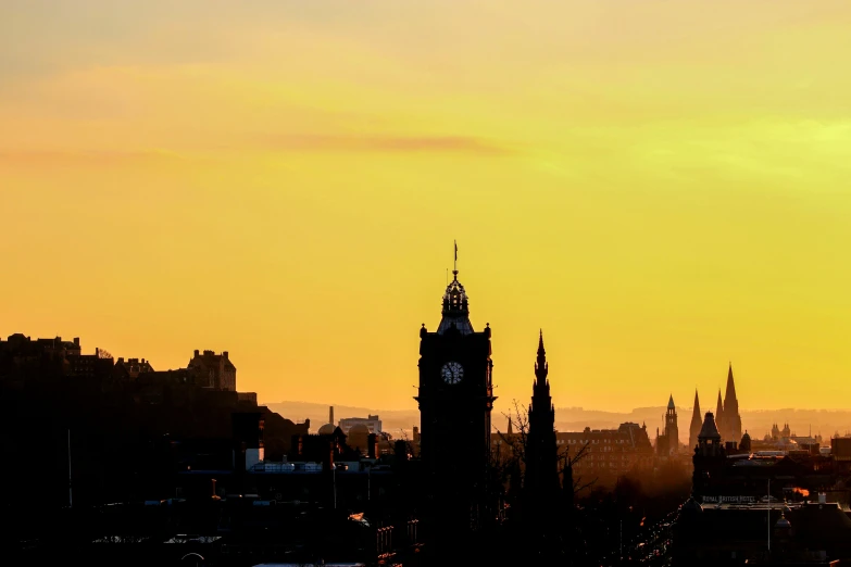 sunset with an overcast sky behind a church and spire