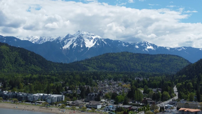 there are some mountains and houses by the water