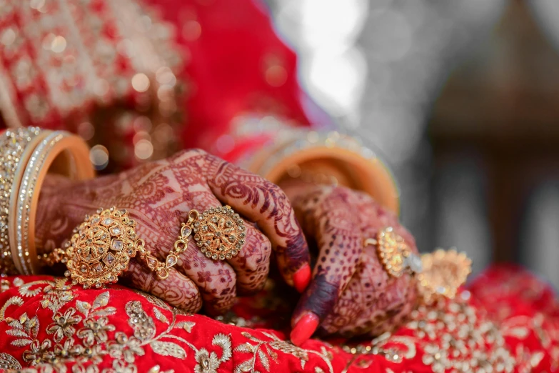 an indian couple holding hands with their bridals and wearing red dress