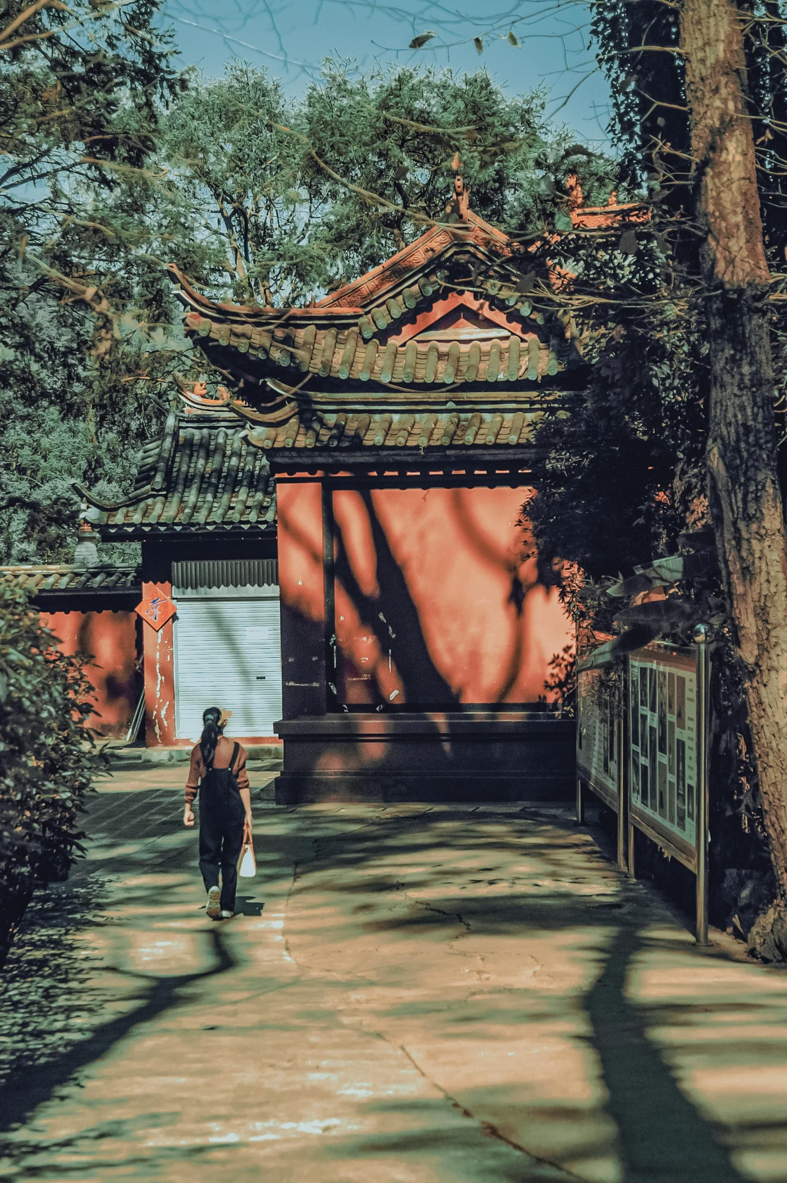 woman walking through outdoor area with red and white buildings