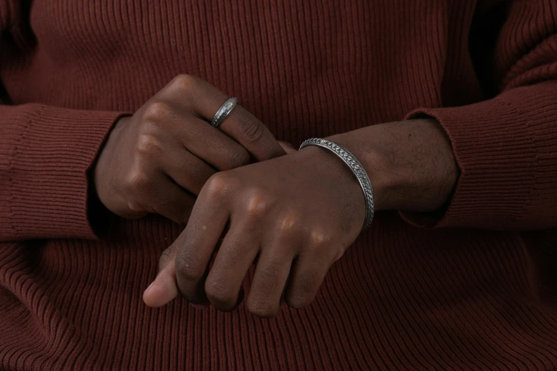 someone wearing a diamond band and an open ring