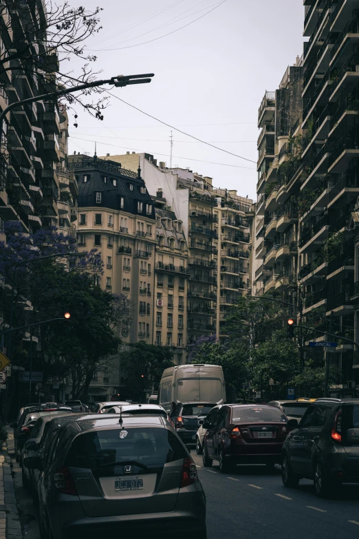 a city street full of cars driving past tall buildings