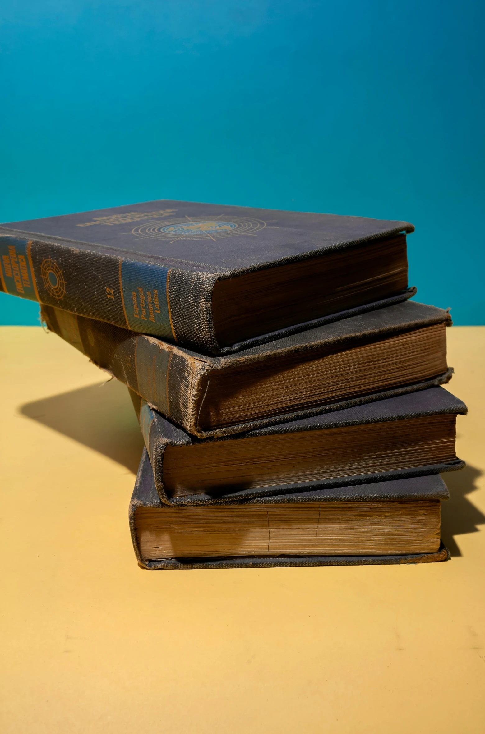 a stack of books laying on top of a yellow table