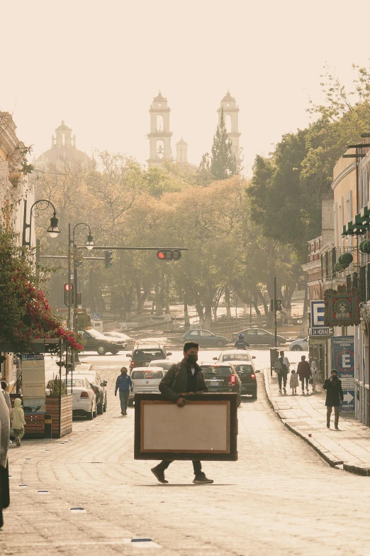 a person sitting on the sidewalk and holding a sign