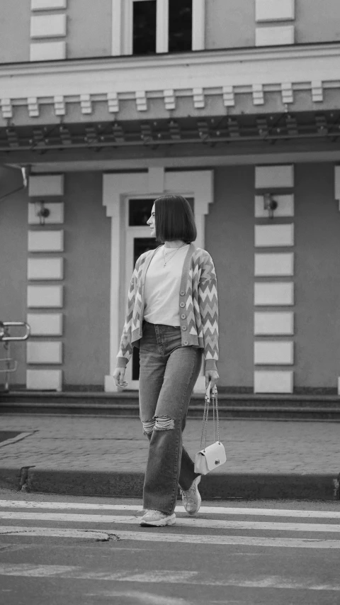 a woman crossing the street holding a purse