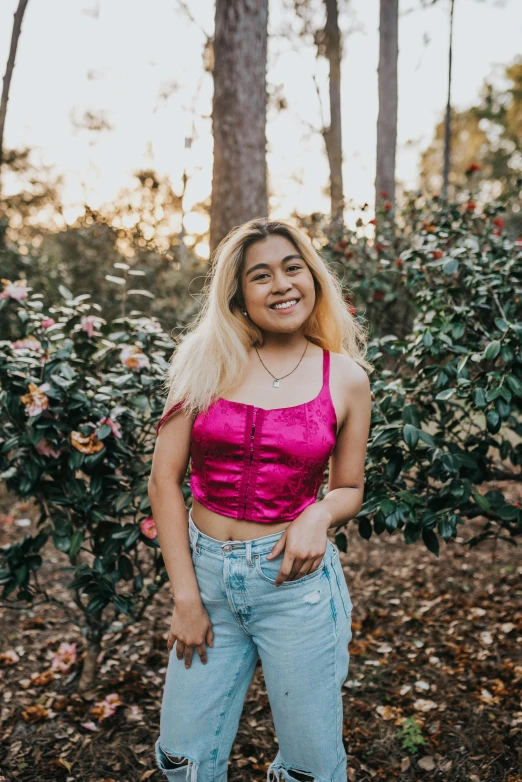 a woman in a pink crop top smiling at the camera