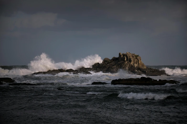 the waves crash onto the rocks at the beach