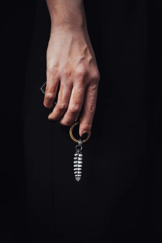 a hand with an arm chain and a key ring