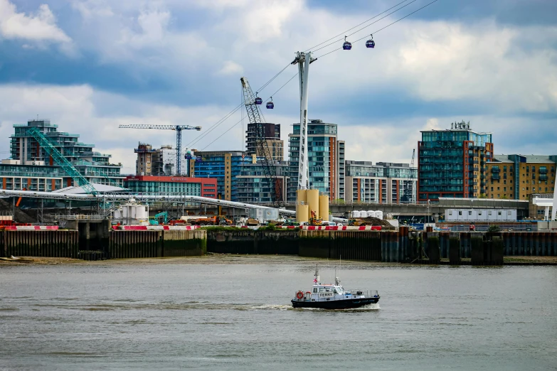 a small boat traveling on a river in front of large buildings