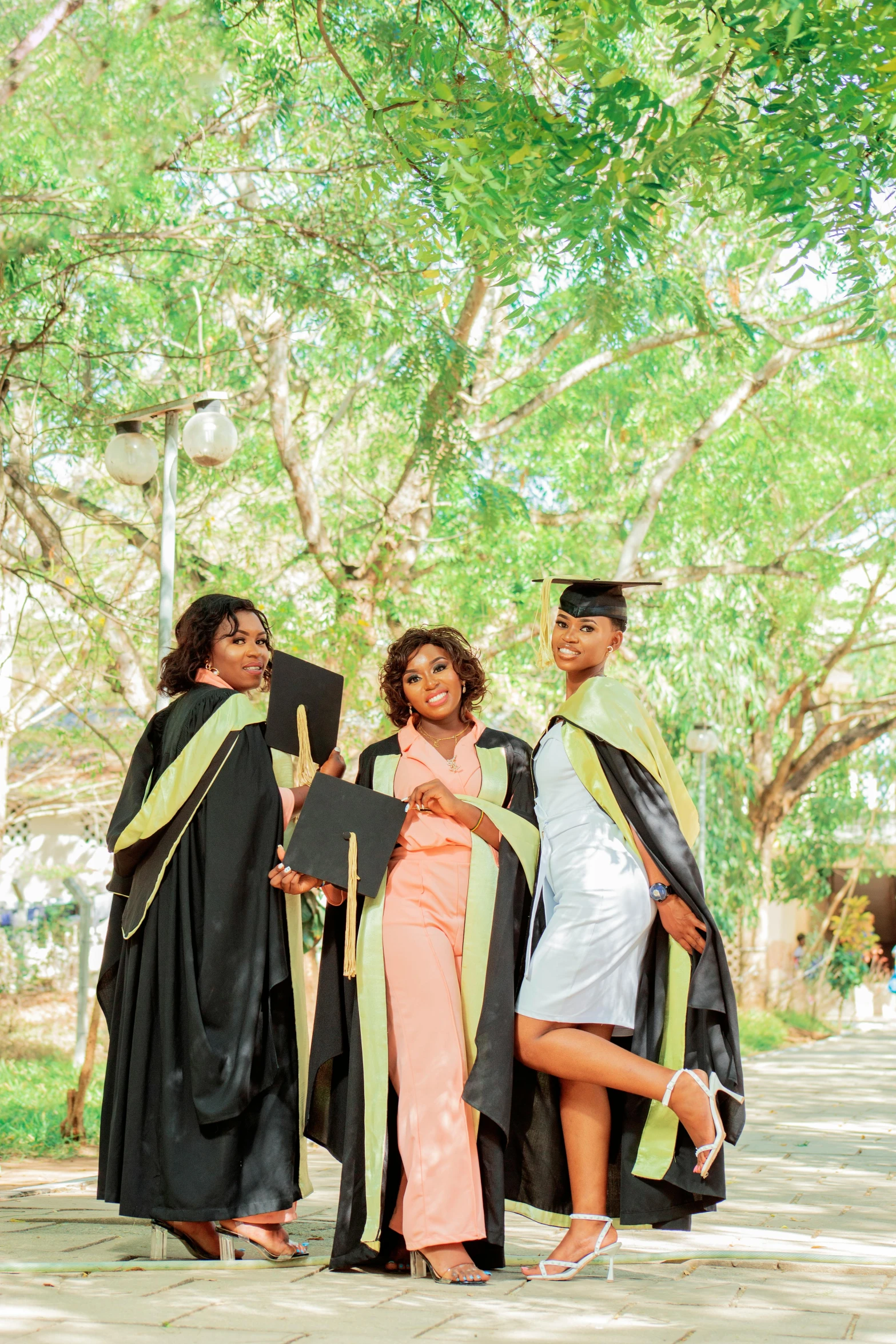 three women are standing together, dressed in graduation gowns