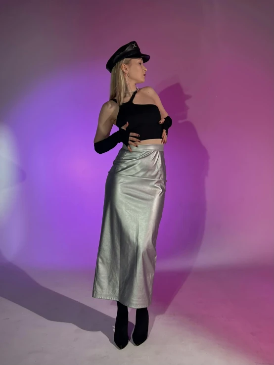 a model posing for a fashion shoot wearing a silver skirt