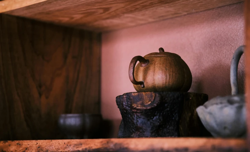 a teapot is sitting on a wooden shelf
