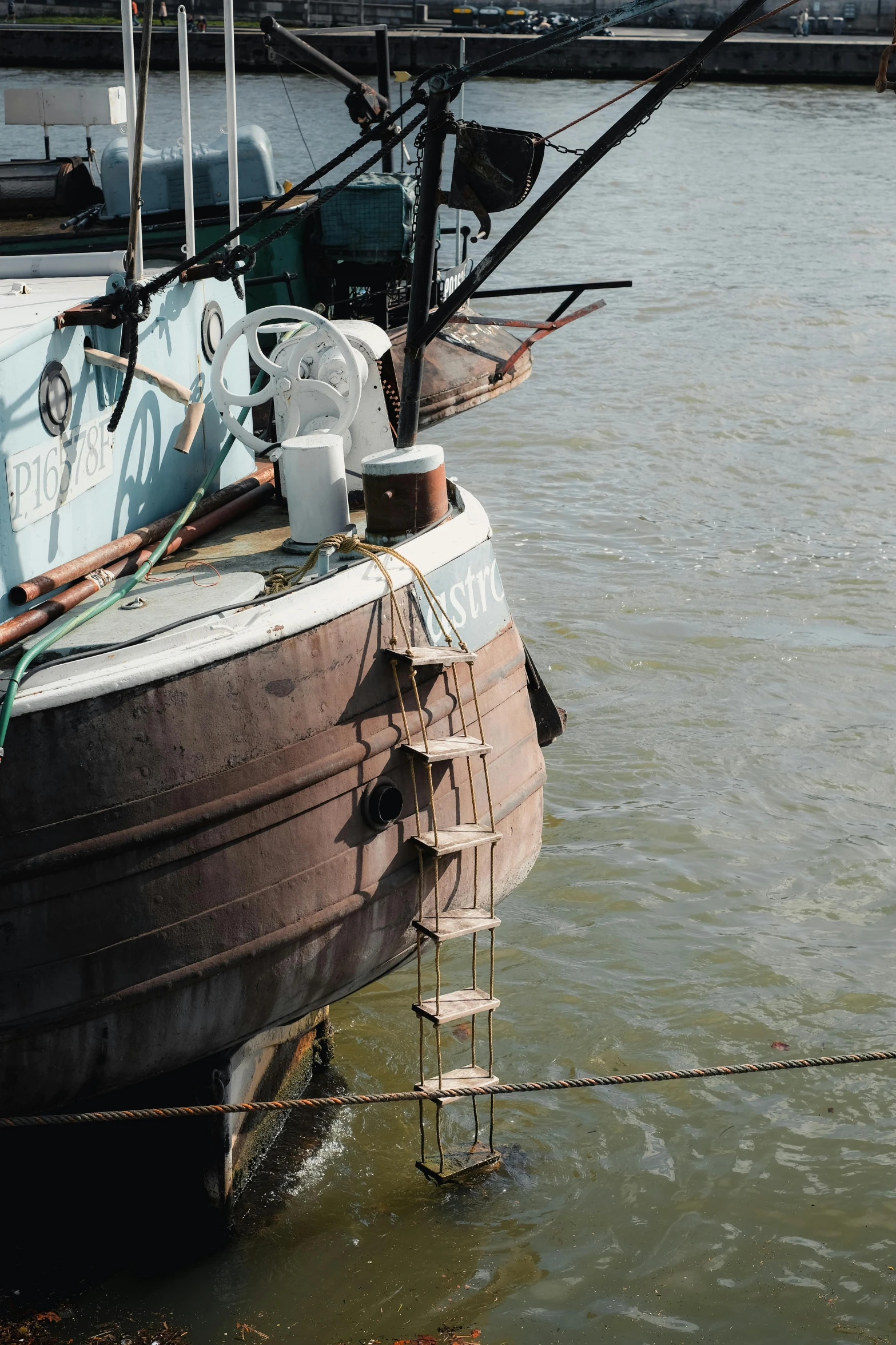 a small boat docked near the dock with ropes on it