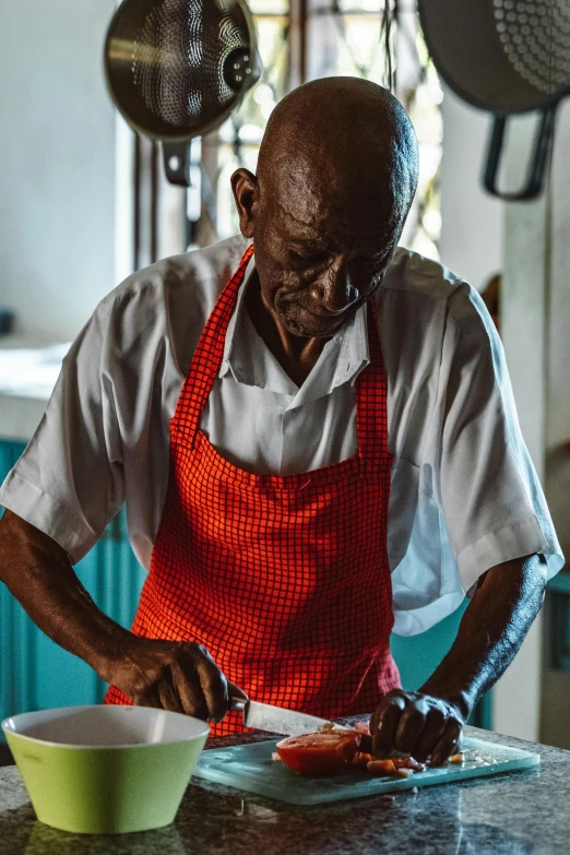 a man in red apron working on soing on a counter