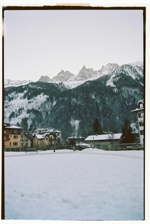 a white snow covered field in front of some houses