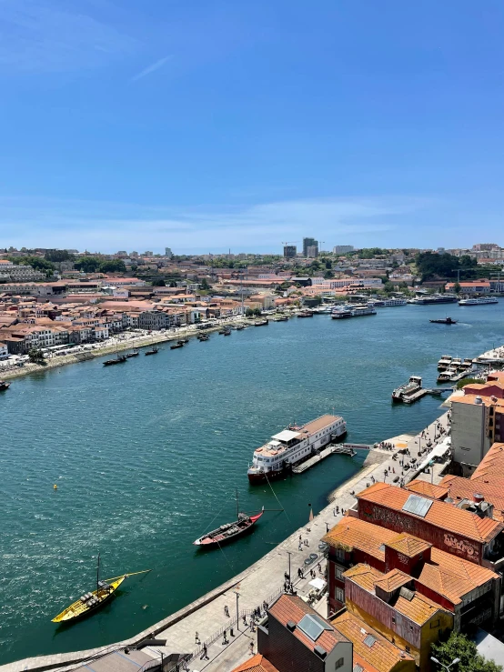 boats are lined up on the river with a city in the background