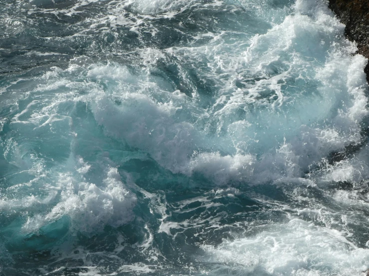 a body of water with lots of white and green waves