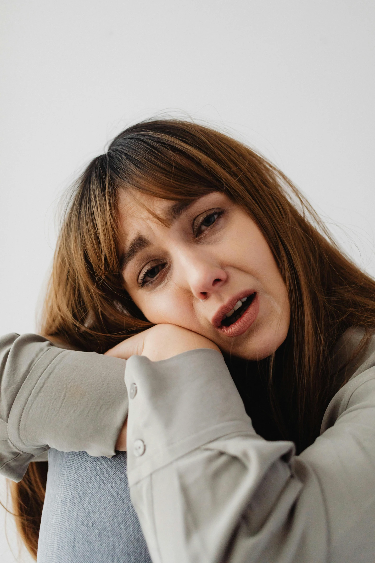 the woman is frowning and covering her face with her hands