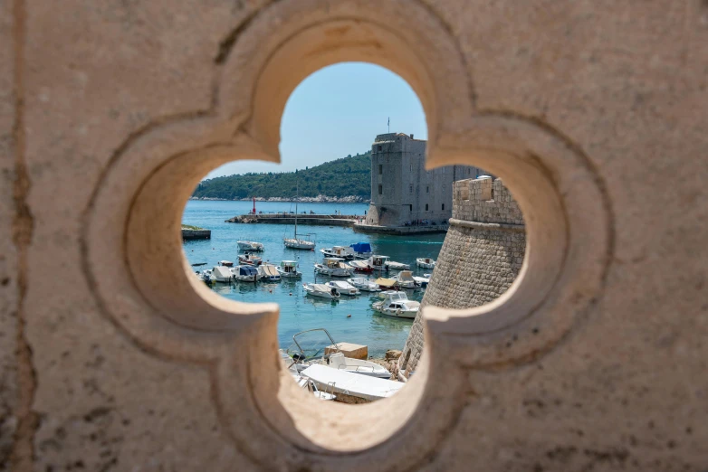 a window view of boats in the water and a castle