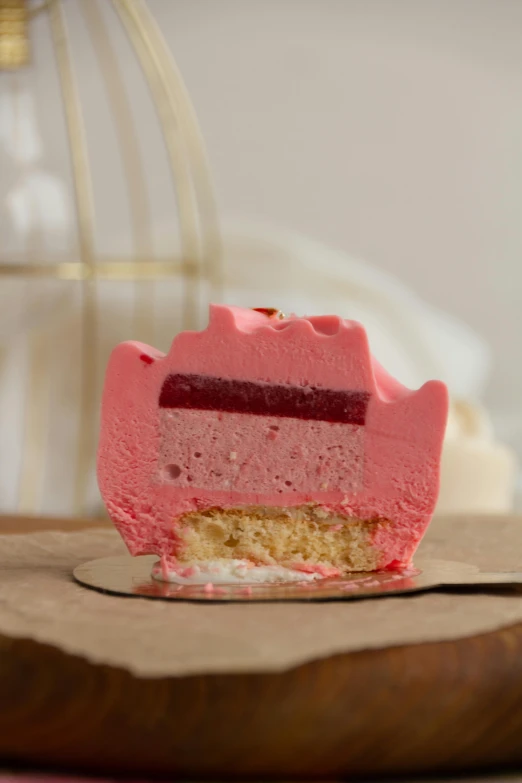 a pink cheesecake shaped like a horse shoe with the bite missing