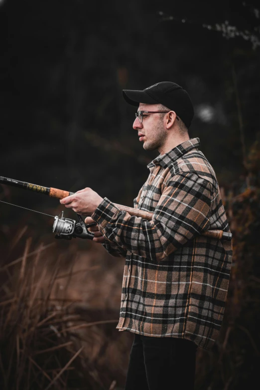 a man in plaid jacket holding a fishing rod
