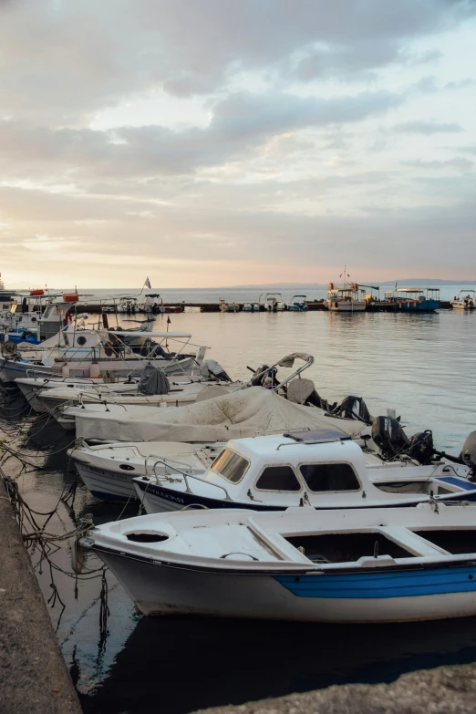 many boats in water near shore at dusk