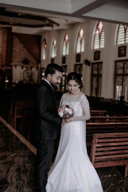 the bride and groom are holding hands in front of pews