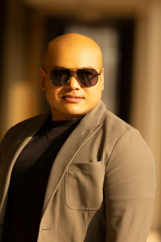 a bald man in sunglasses posing for a po