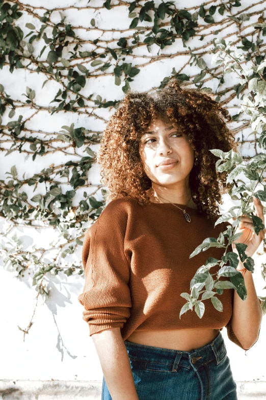 an attractive woman with curly hair wearing jeans