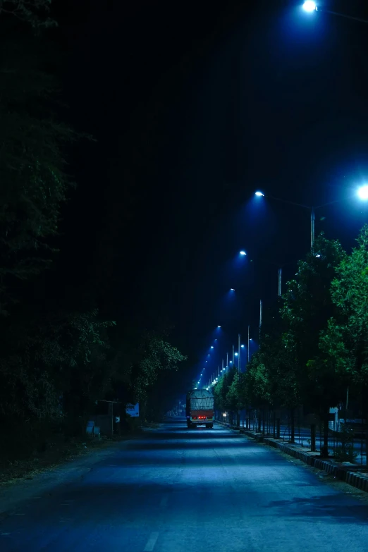 a long, empty road is lit up with street lights