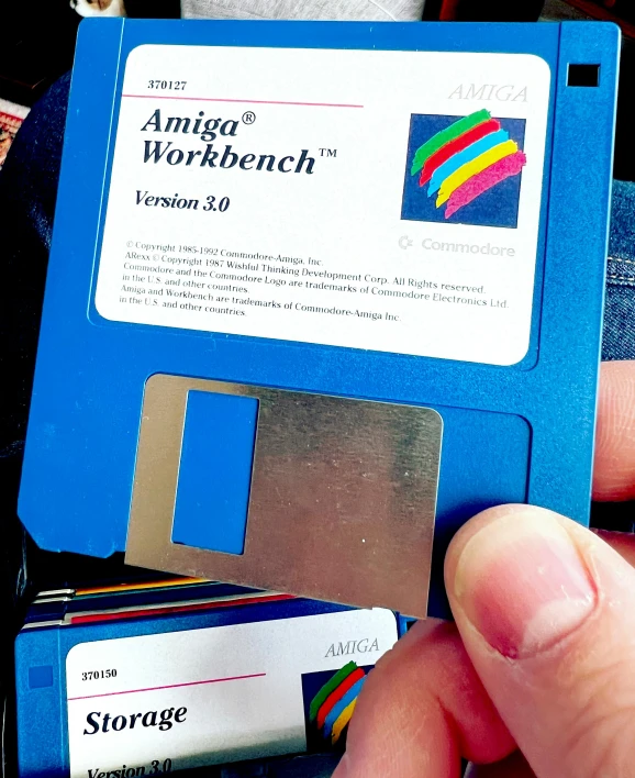 a person holds a floppy disk and another has a credit card