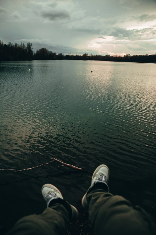 a person with their legs crossed on the edge of a body of water