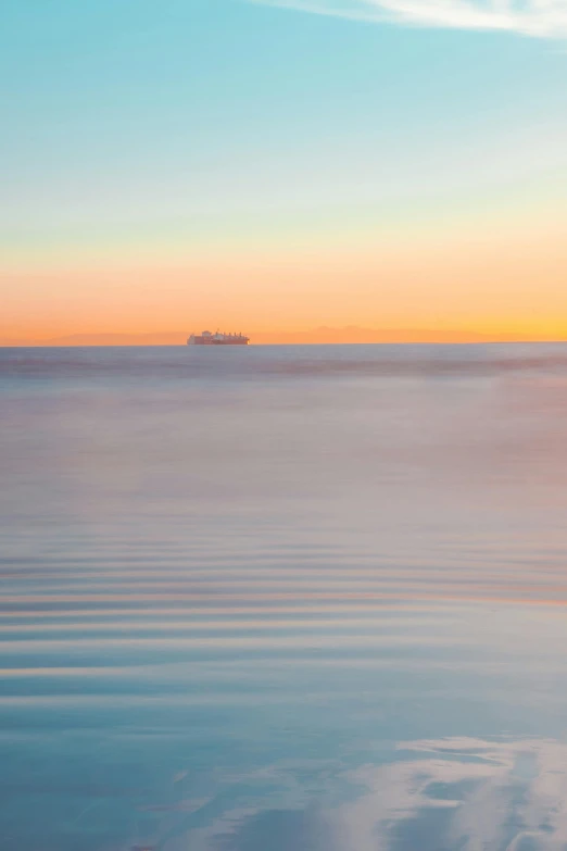 a boat floating in the ocean at sunset