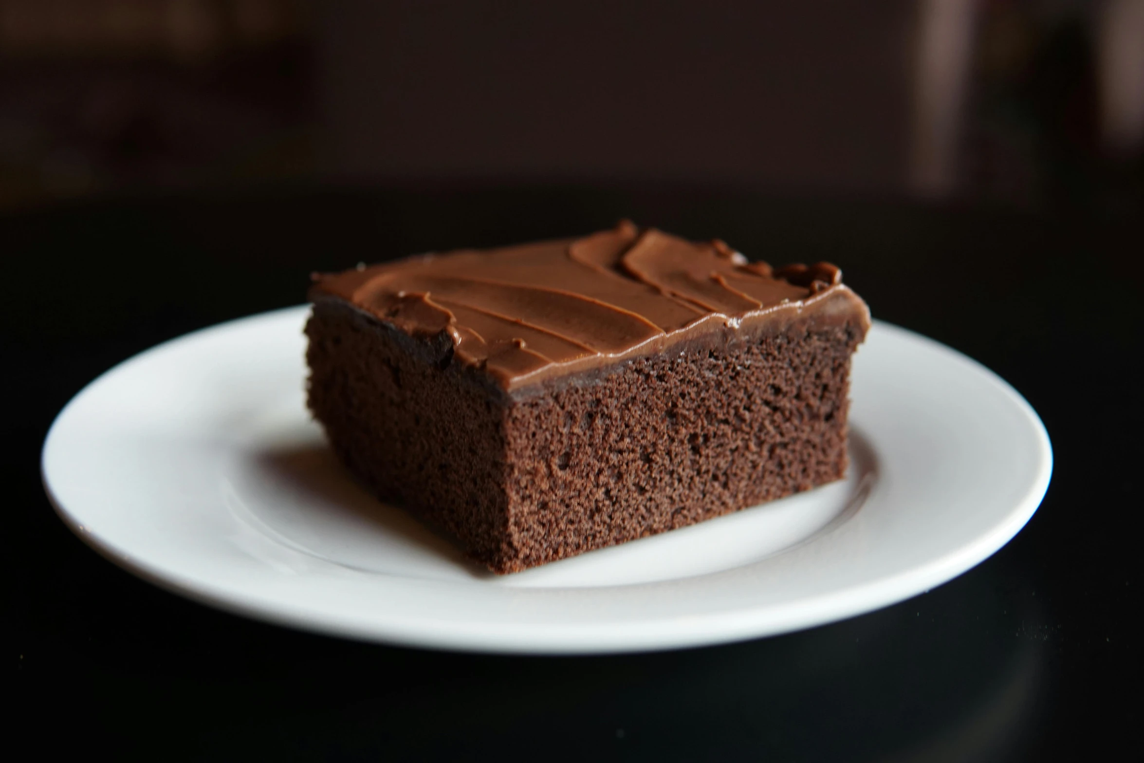 a white plate topped with a piece of chocolate cake