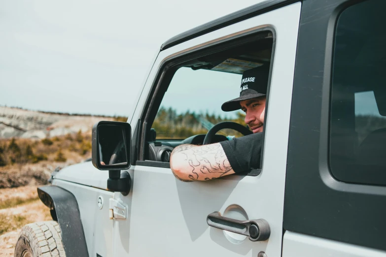 a man with a tattoo looking out of the window