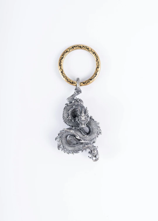 an animal keychain is adorned with gold and silver