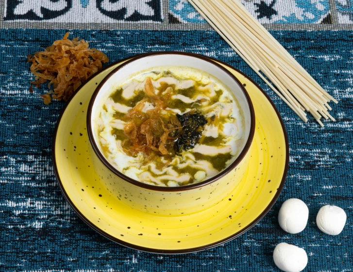 some noodles with meat in a bowl next to chopsticks