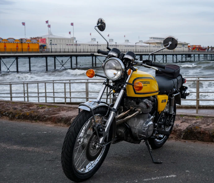 a motorcycle parked on a roadside by the water