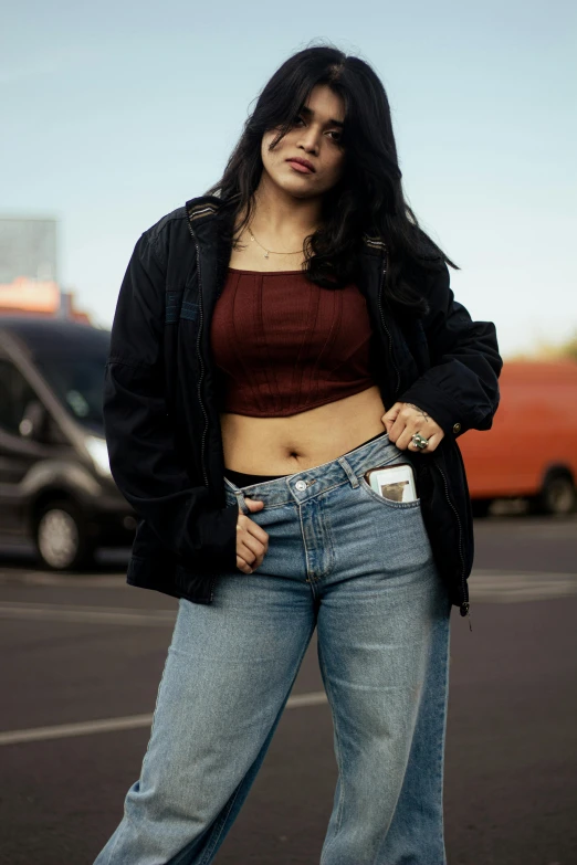 a woman with long dark hair is in jeans and a cropped shirt